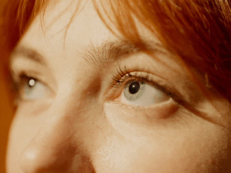 Life Extension Europe: Woman with freckles and light-coloured irises looking upwards with sunshine on the face